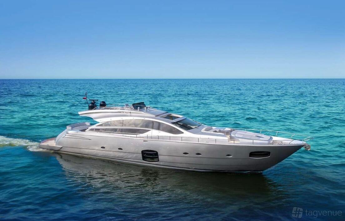 A luxury yacht with a silver exterior cruising on clear blue water at Florida Yacht Charters & Sales.