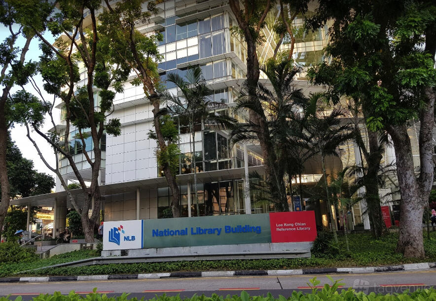 A café with tall glass windows, leafy landscaping, and outdoor signage at OTC Cafe / Event Space.