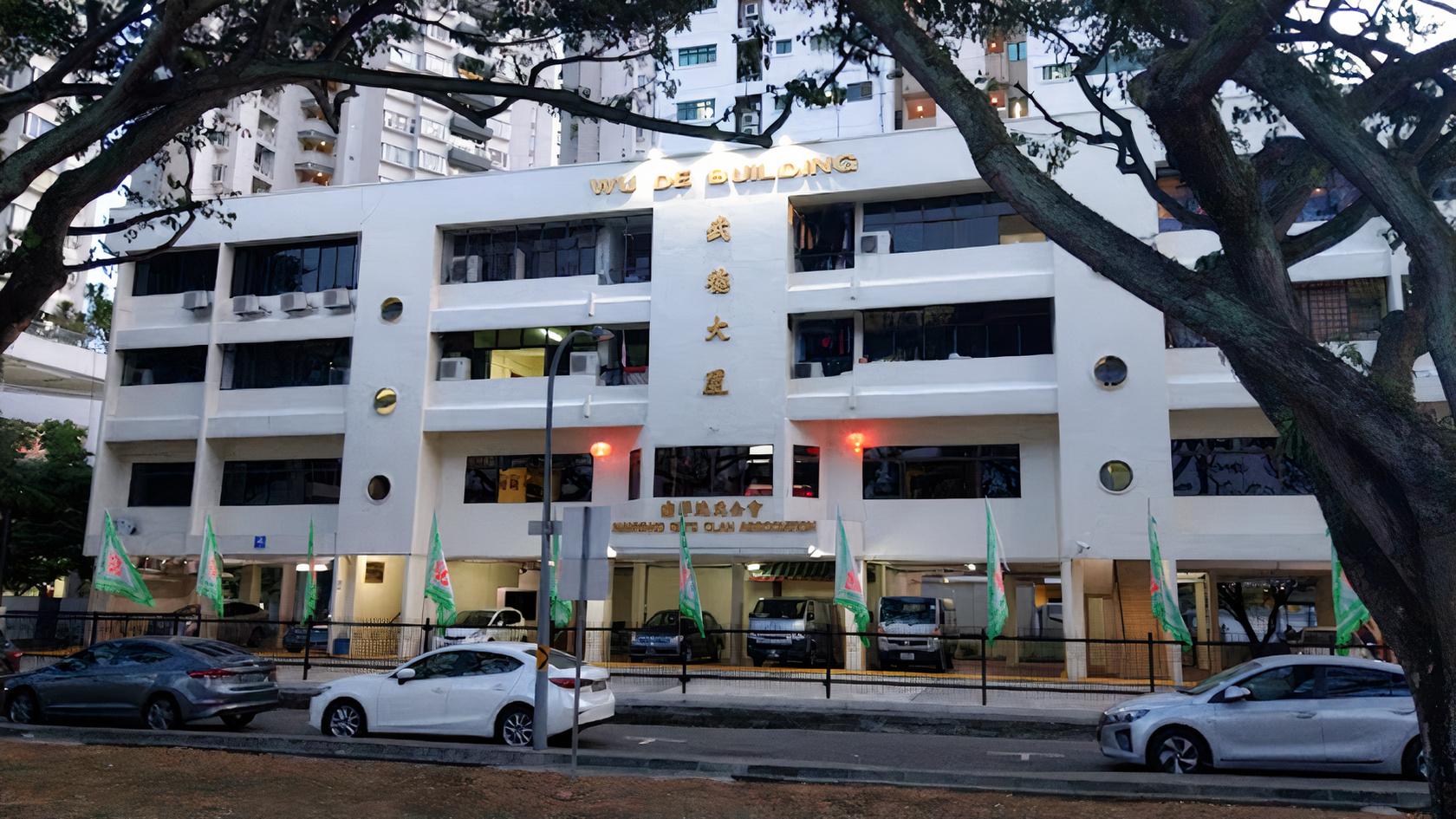 A versatile event space with a white three-story facade, large windows, and gold signage at HERE.