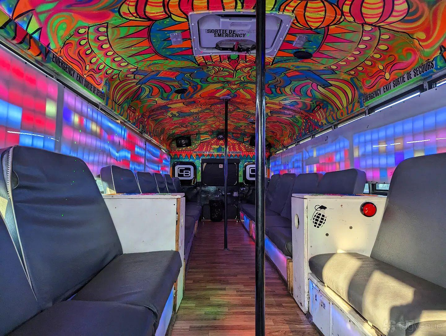 A party bus with LED wall lighting, psychedelic painted ceiling, and cushioned bench seating at Circusbus Party Bus Toronto.