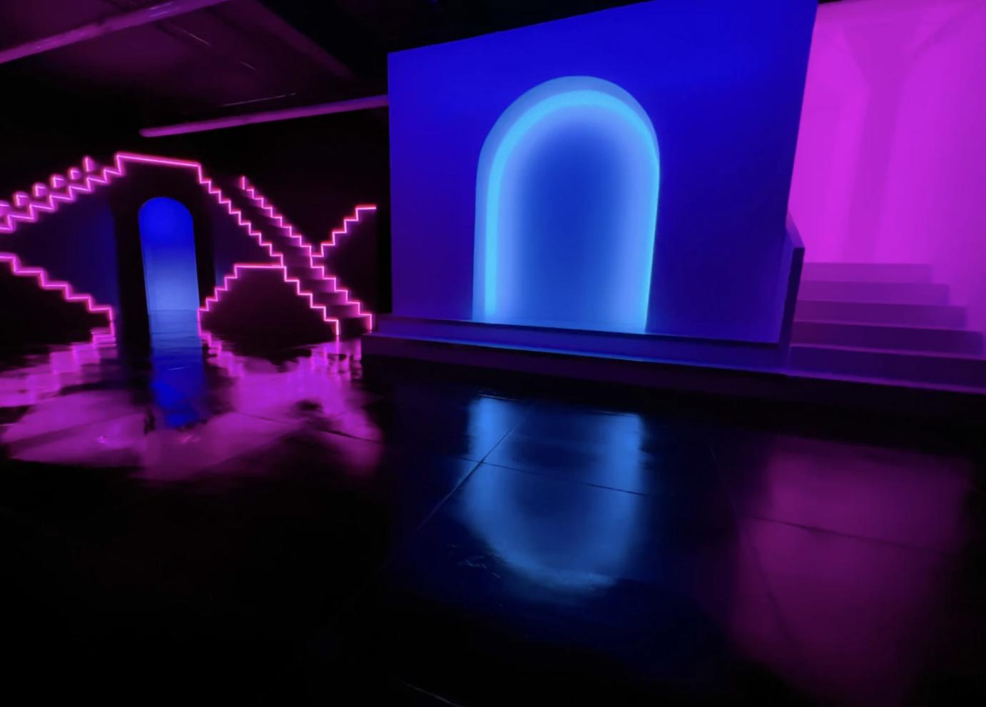 A photo studio with neon-lit archways, geometric LED accents, and glossy black floors at Neon Oasis Studio.