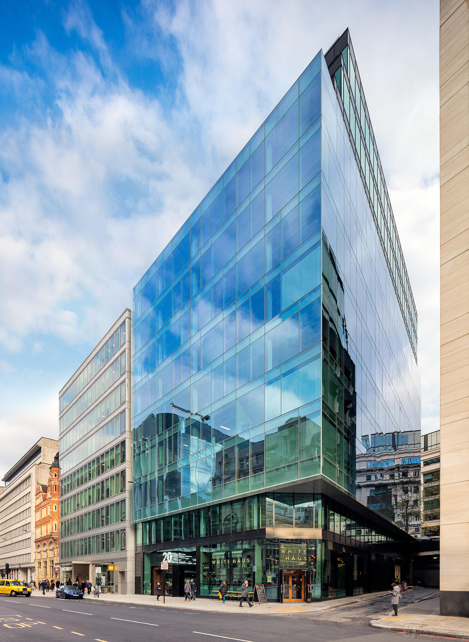A modern glass-fronted building with reflective windows at HubHub 20 Farringdon Street.