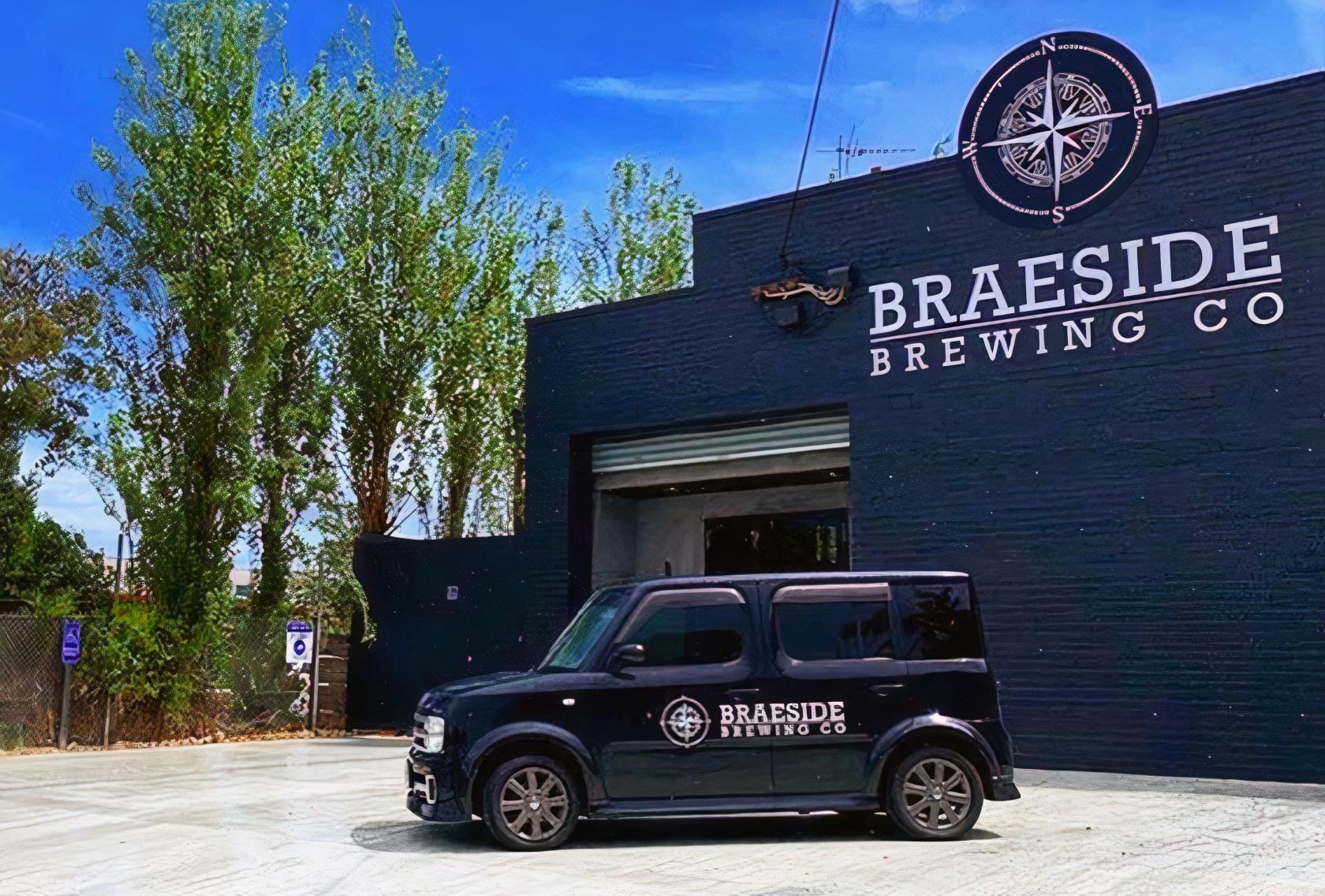 A brewery exterior with large signage, black facade, and a branded van parked in front at Braeside Brewing Co.