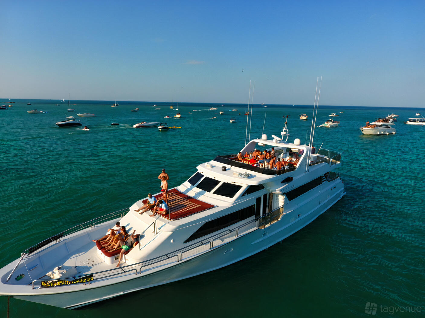 A large yacht with two sun decks and groups of people lounging on open water at Chicago Party Yacht.