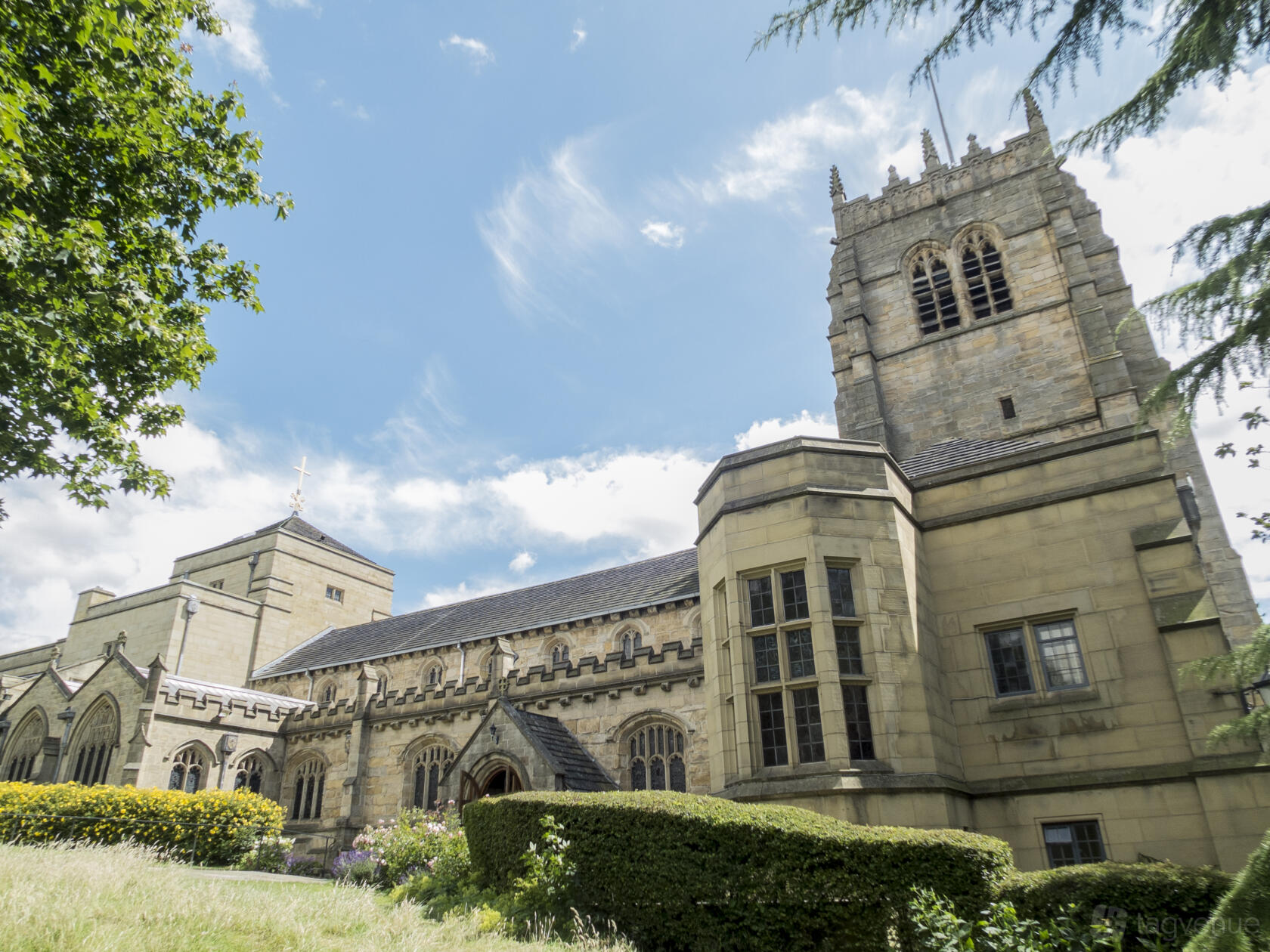 A historic church with Gothic stone architecture, arched windows, and a central tower at Bradford Cathedral.