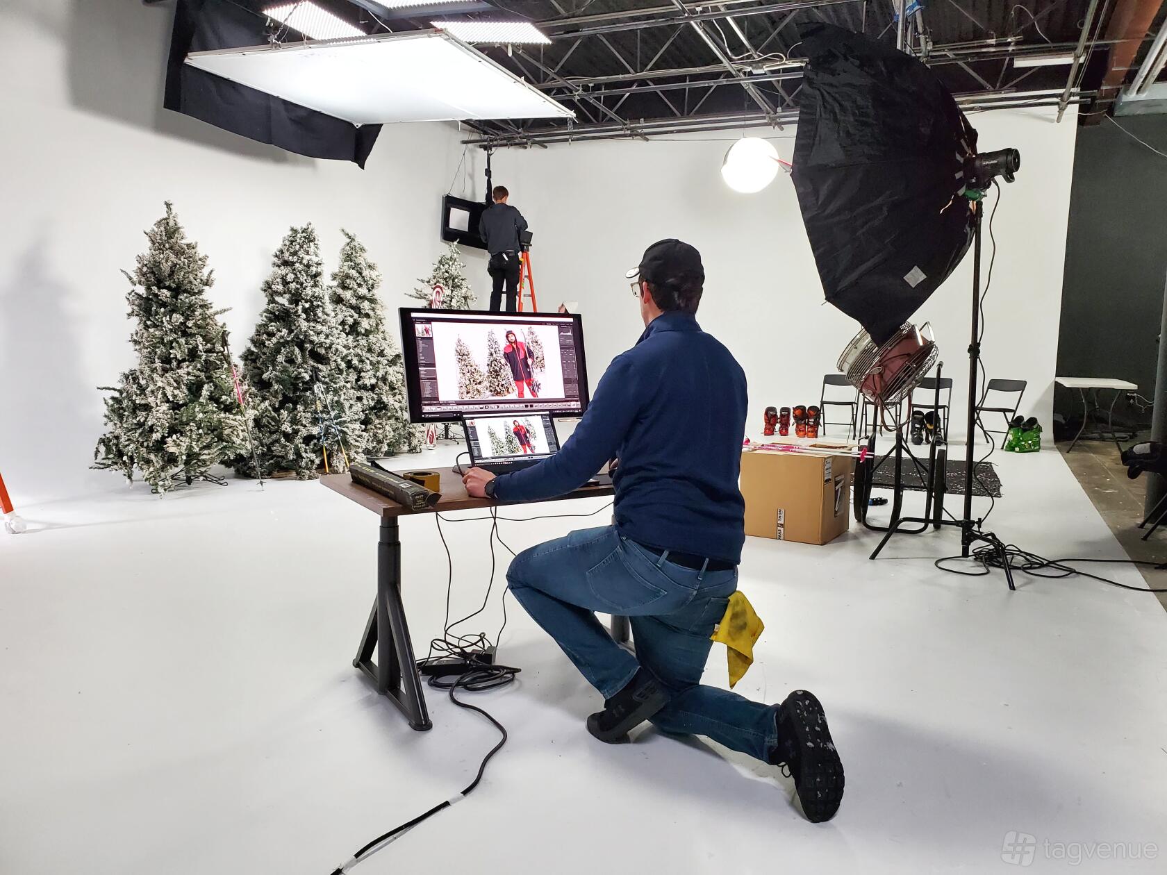 A photo studio with a two-cornered white cyclorama wall, studio lighting, and holiday props at Lens Head Studios.
