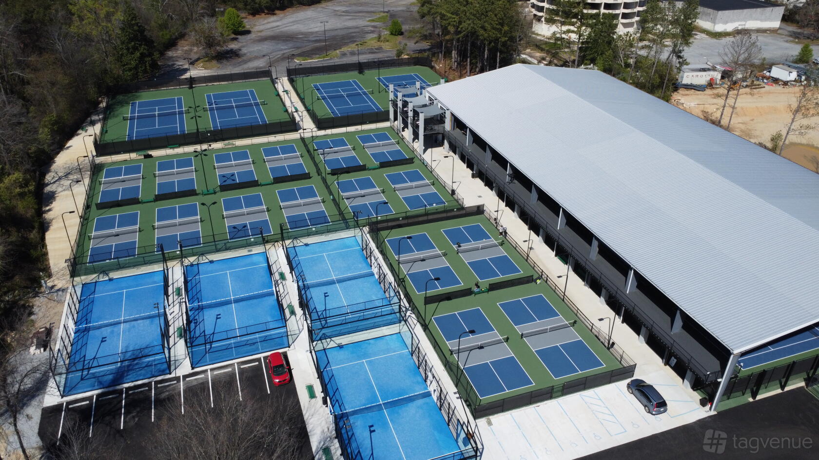 An outdoor sports facility with multiple tennis and pickleball courts next to a large building at ITA Atlanta.