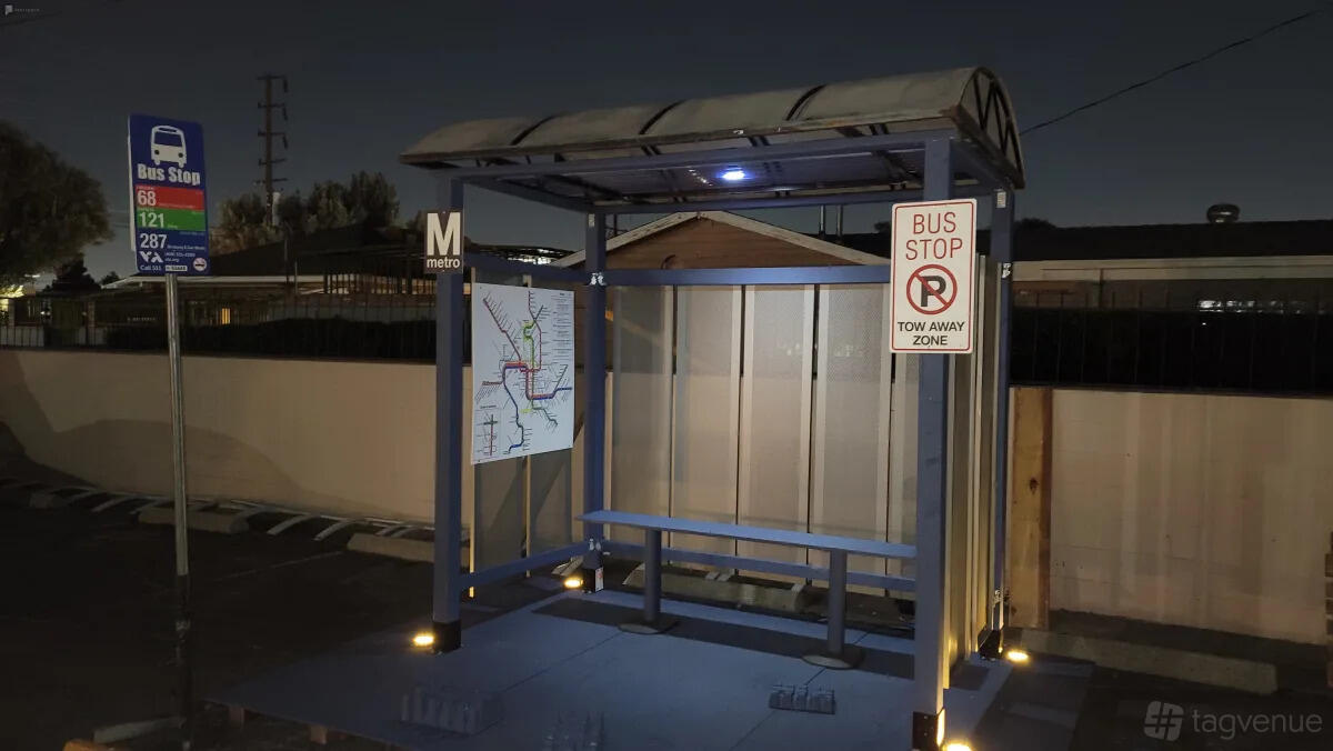 A photo studio set with a realistic bus stop shelter, bench seating, and metro signage at Cosmic Cube Creative Studio.