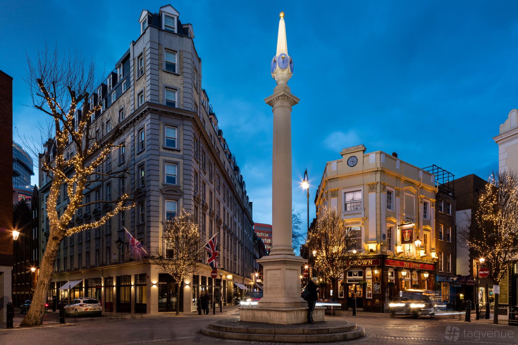 A hotel exterior with illuminated windows, British flags, and festive lights at Radisson Blu Hotel, London Mercer Street.