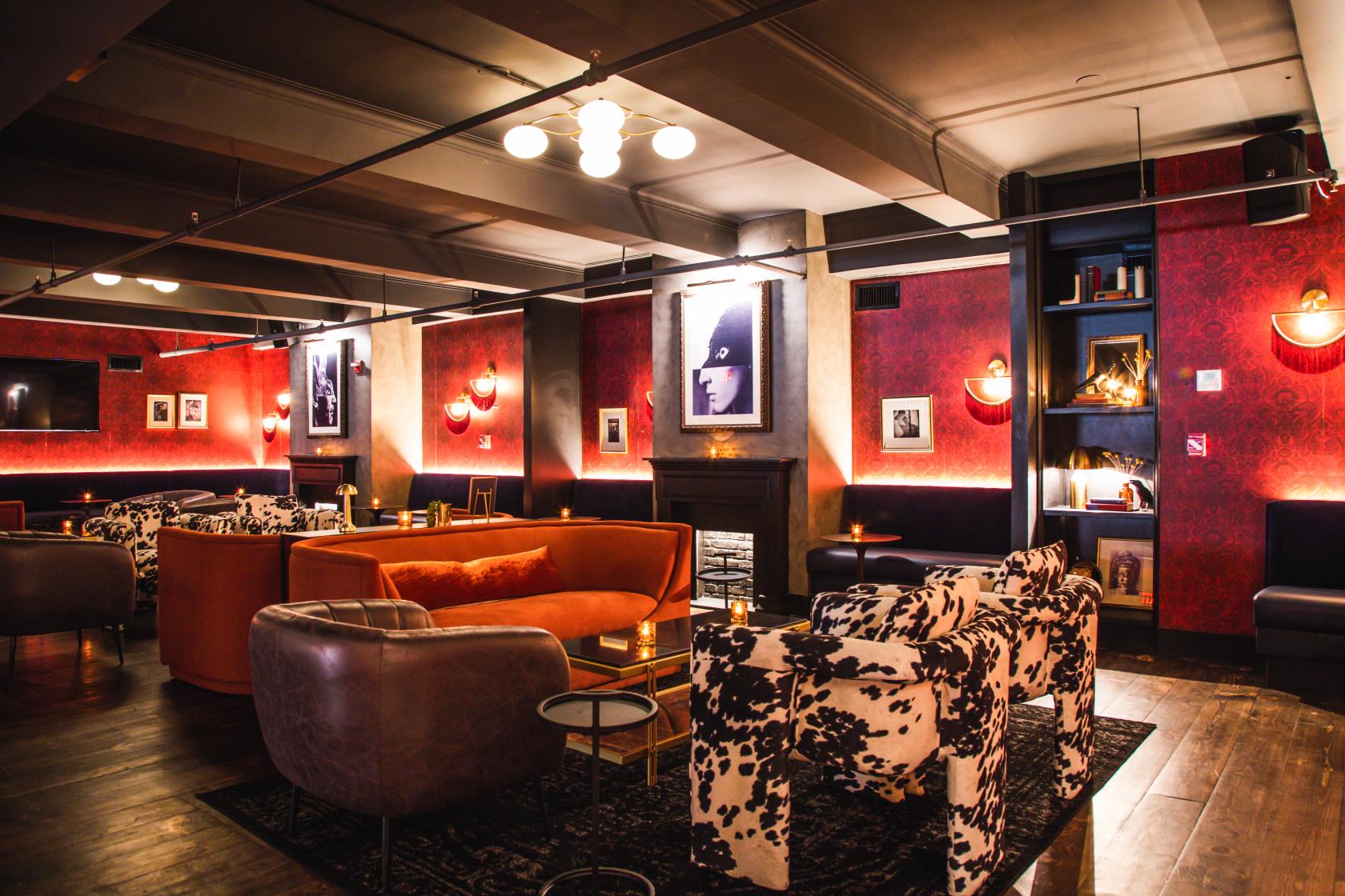 A function room in a bar with patterned lounge seating, warm lighting, and framed artwork at 5th and Mad.