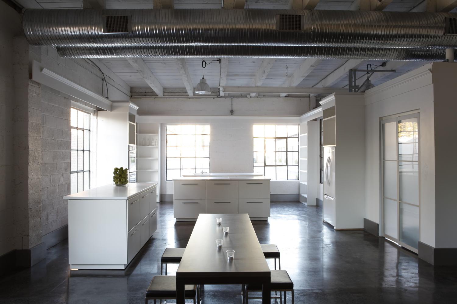 An event venue with polished concrete floors, exposed ductwork, and large industrial windows at 18 Label Studios.