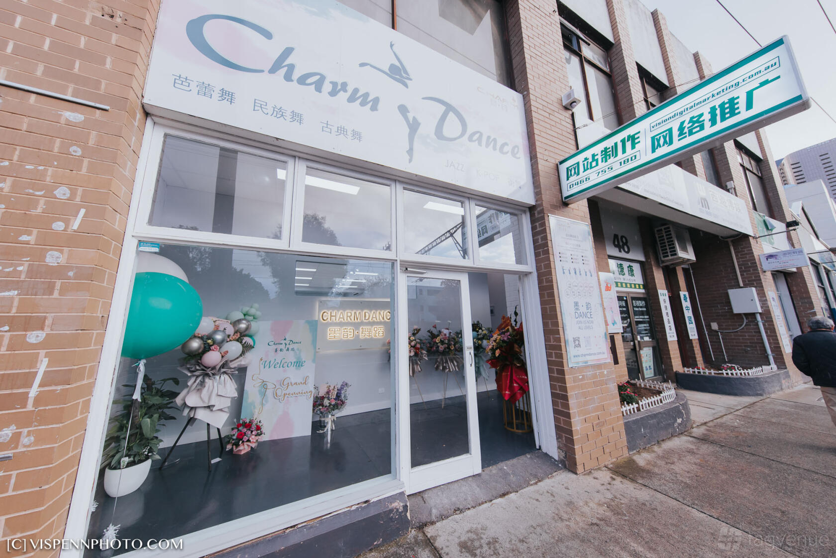 A dance studio with a glass storefront, balloon display, and floral arrangements at CharmDance.