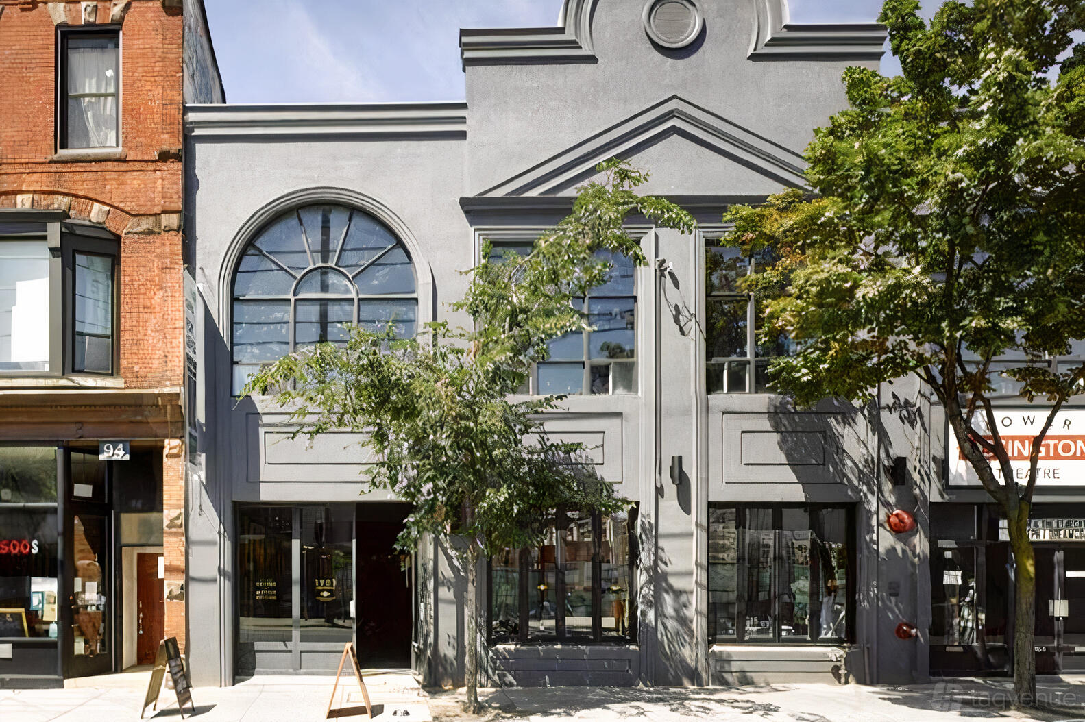 A restaurant with a gray facade, arched windows, and a street-facing entrance at Azhar Kitchen + Bar.