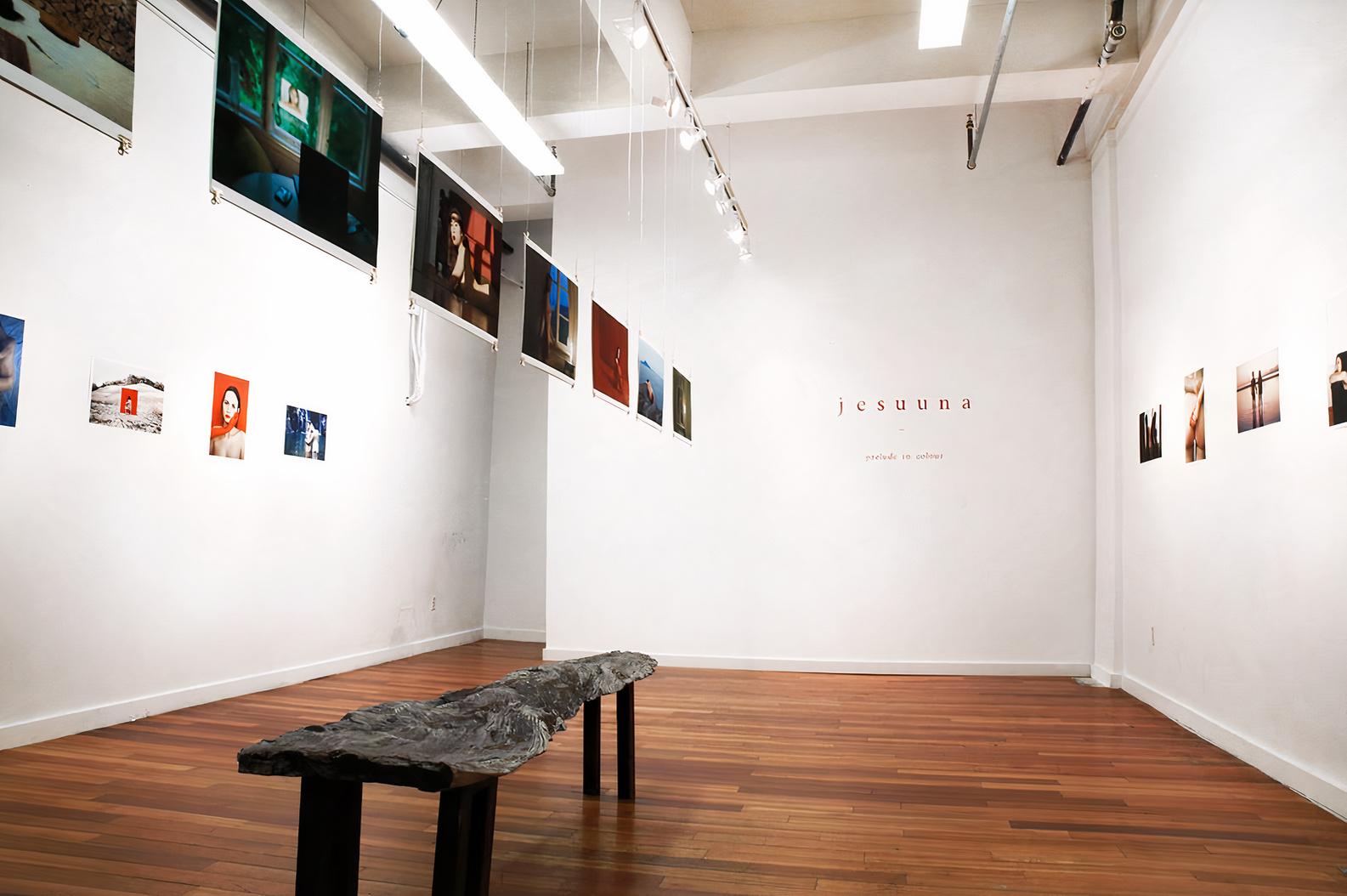 A gallery with polished wood floors, white walls, and contemporary artwork displayed at Little Raven Gallery.