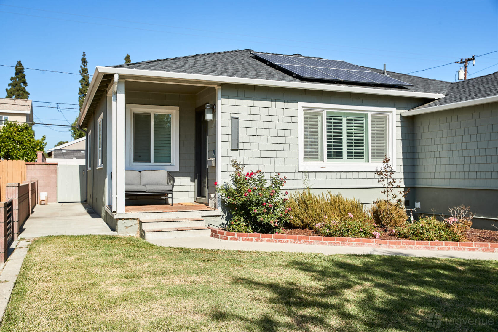 A film and photo studio with a front lawn, gray siding, and a small seating area on the porch at Iroquois.