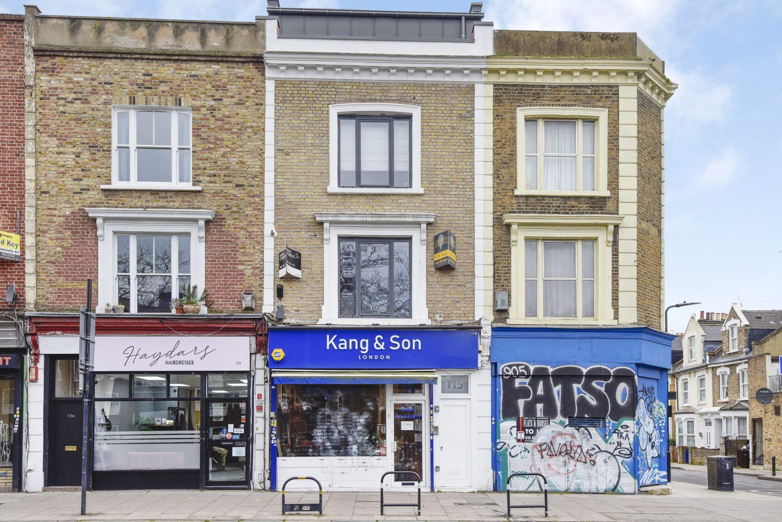 A gallery with a brick facade and blue storefront signage at Kang & Son.