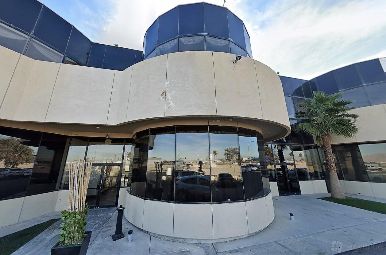 A film and photo studio with a glass facade, tall windows, and palm trees at BoothMeUp Las Vegas.