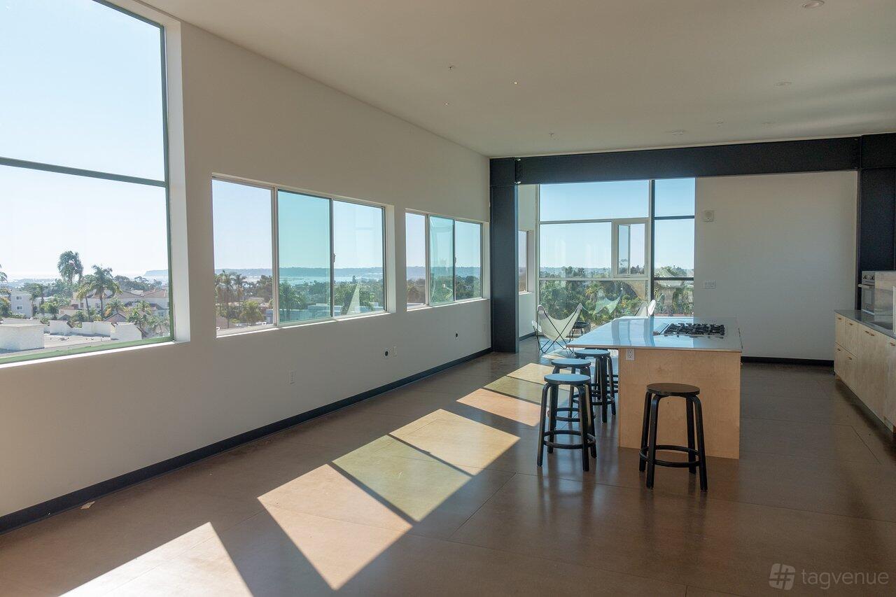 A function room in a hotel with floor-to-ceiling windows, ample natural light, and a kitchen island at Abpopa Hillcrest.