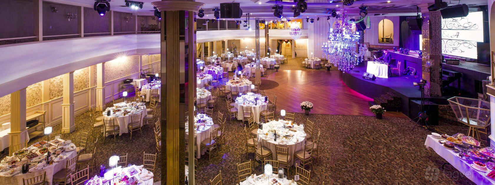 An event venue with a spacious dance floor, chandeliers, and round tables with gold chairs at National Event Venue.