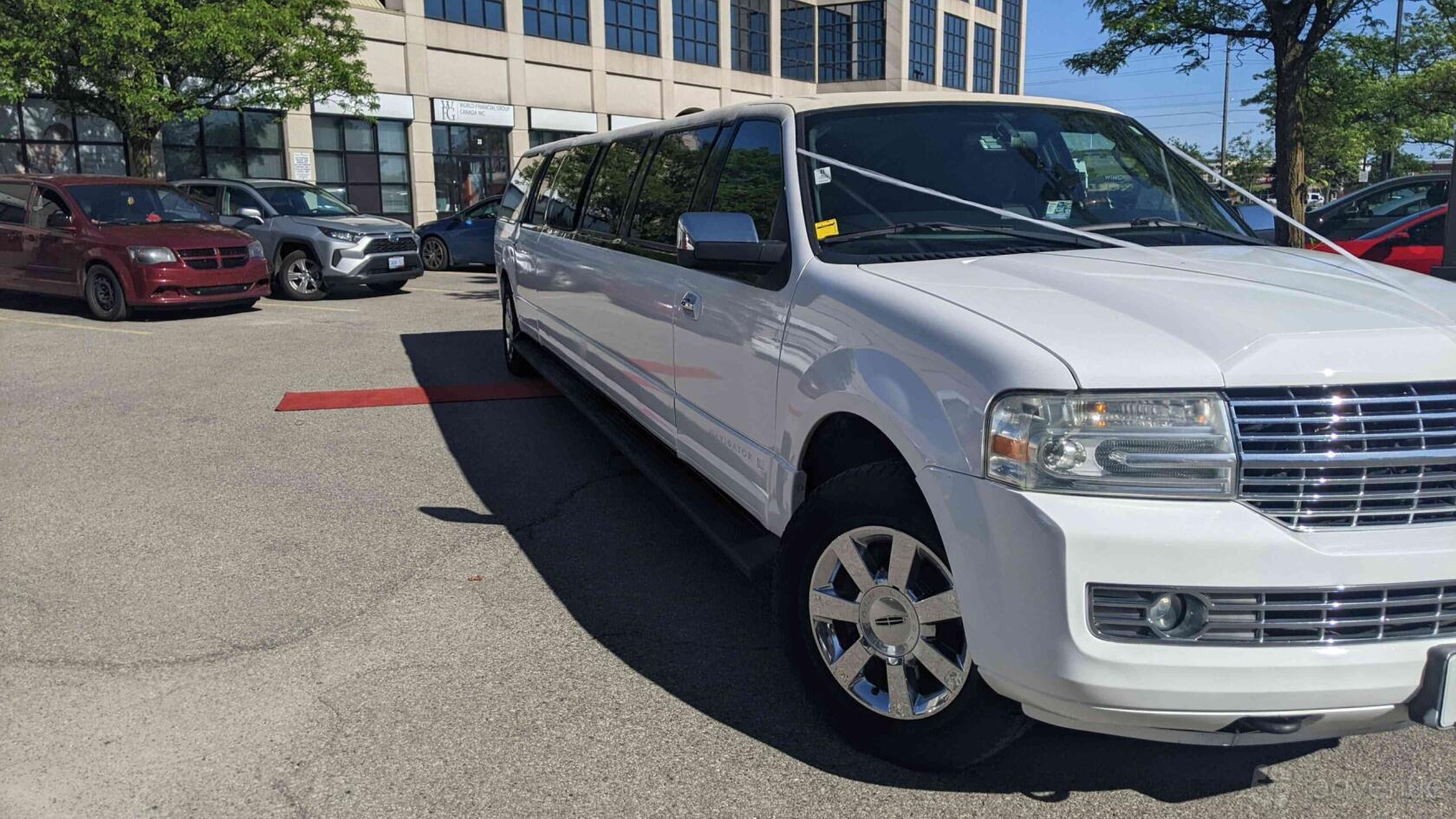 A stretch SUV party bus with chrome wheels parked outside GoodTime Limo & Party Buses - Mississauga.