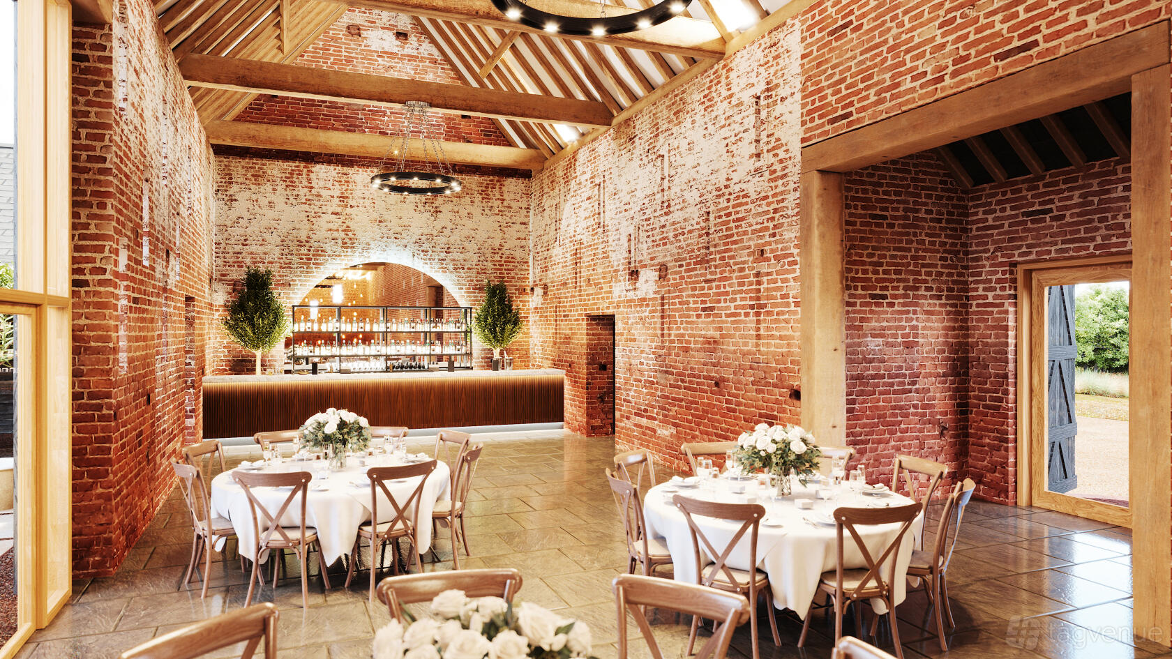 A hall with exposed brick walls, timber beams, round tables with white linens, and a wooden bar at Copdock Hall.