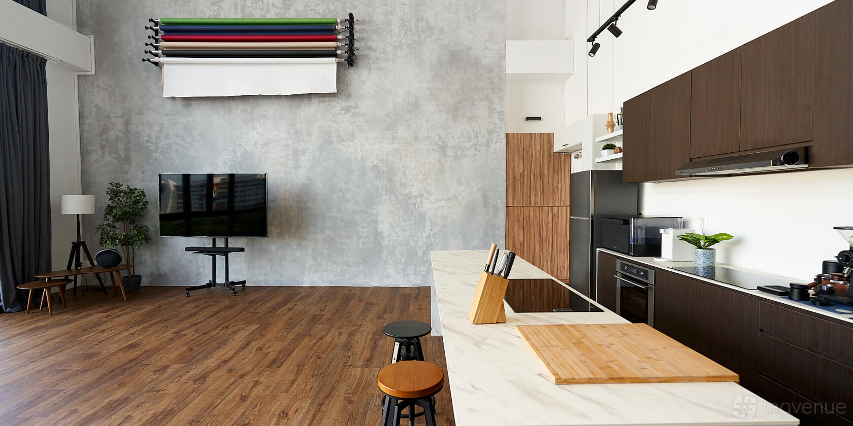 A kitchen with a marble countertop island, built-in appliances, and backdrop rolls at Studio Recreate.