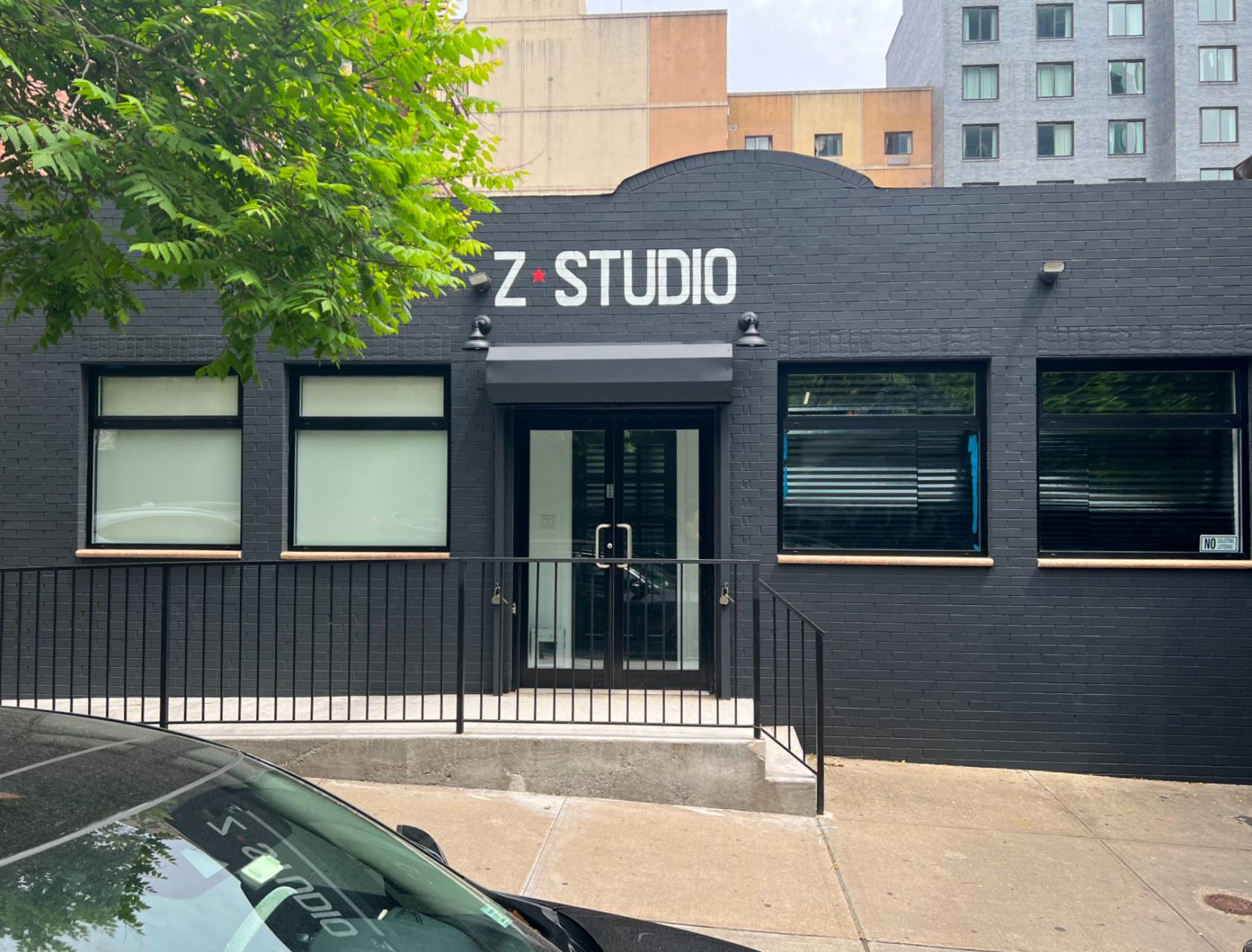 A film and photo studio with a black brick facade, large windows, and a glass door entrance at Z studio 40th rd.