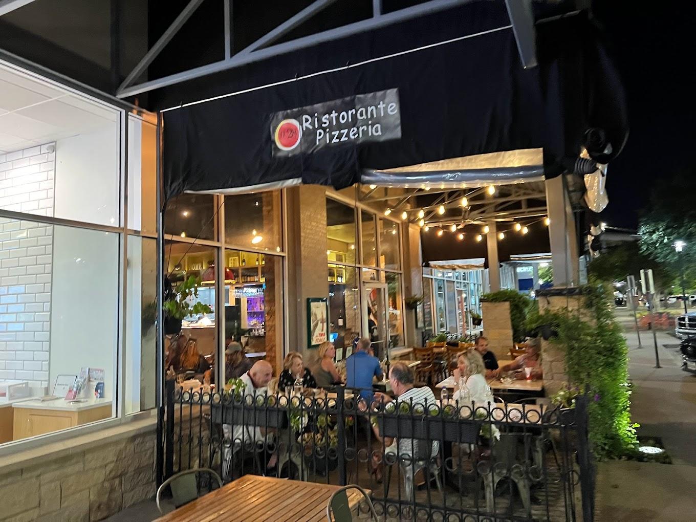 A restaurant terrace with outdoor seating, string lights, and greenery at Numero 28 Allen Ristorante Pizzeria.