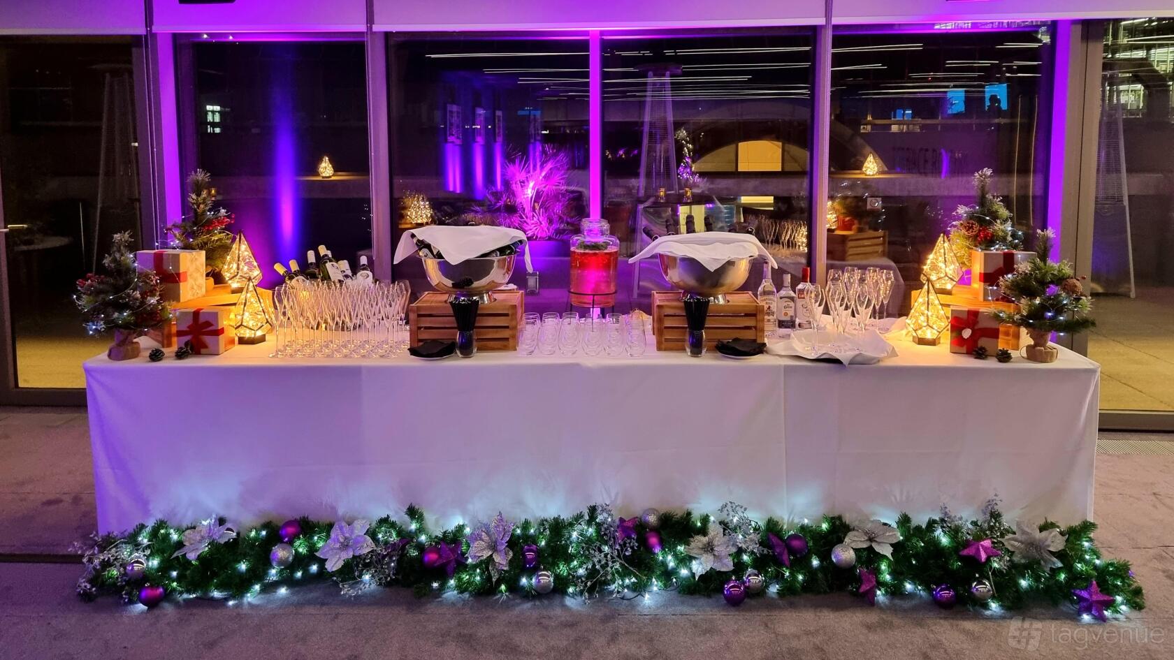 A function room with a decorated drinks station, ice buckets, glassware, and festive lighting at Events at No6.
