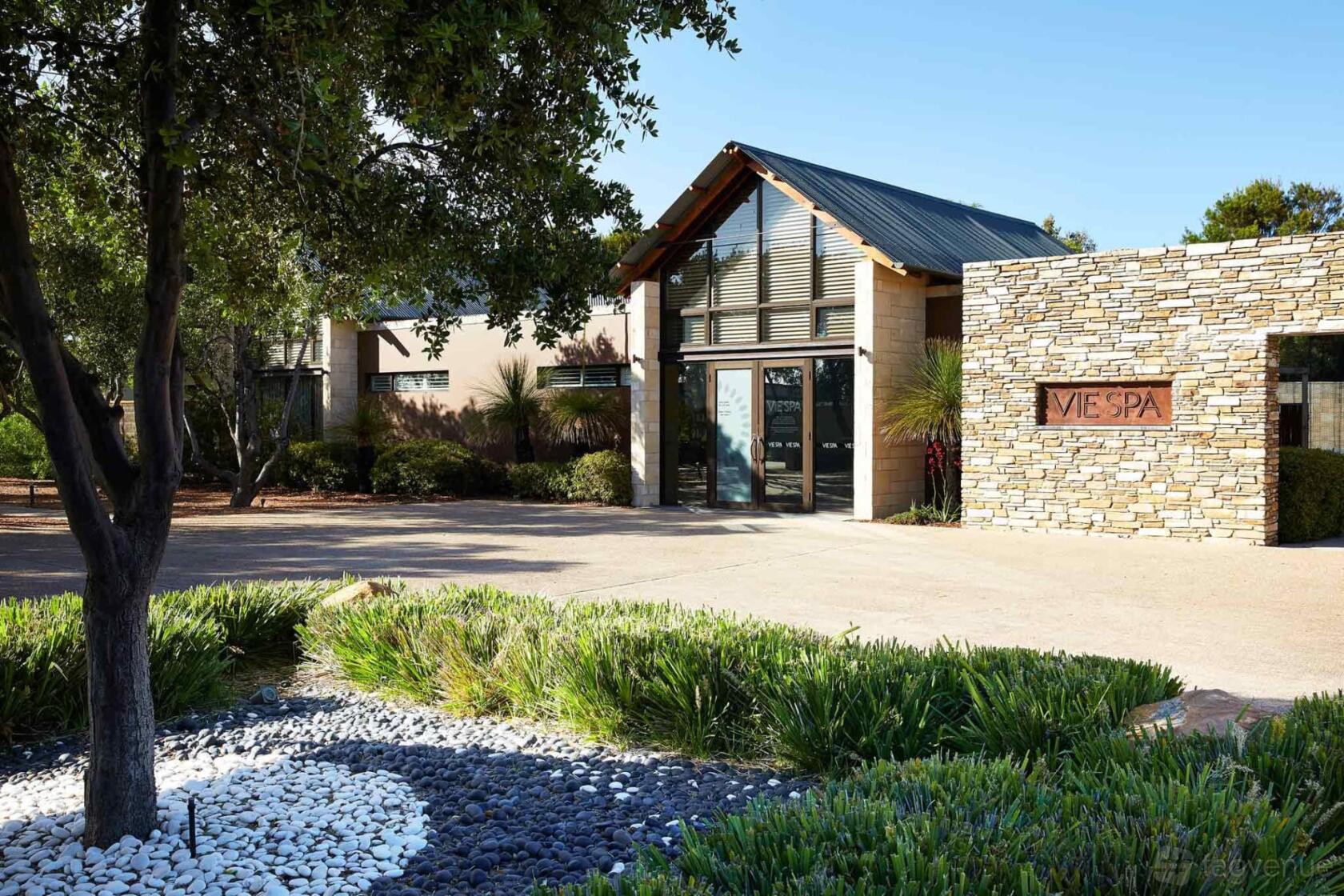 A hotel with stone walls, landscaped garden beds, and large windows at Pullman Bunker Bay.