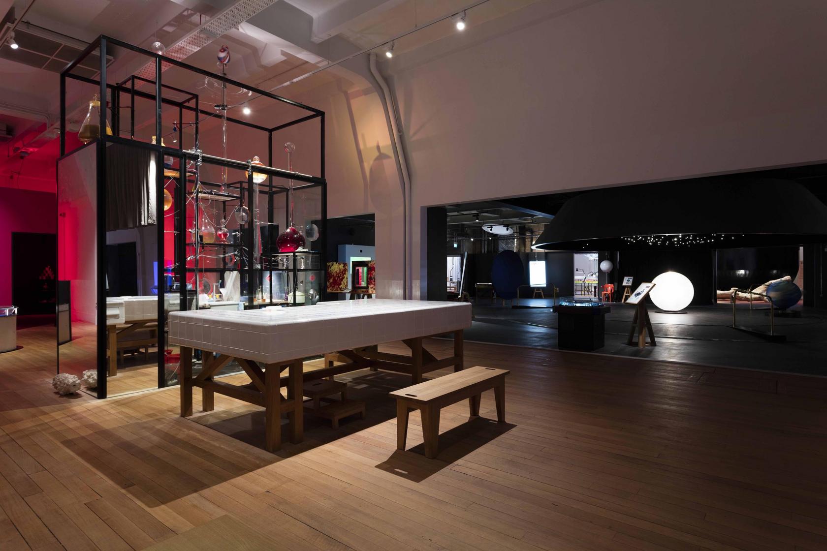 A museum gallery with interactive science exhibits, wooden flooring, and display tables at the Science Museum Wonderlab.