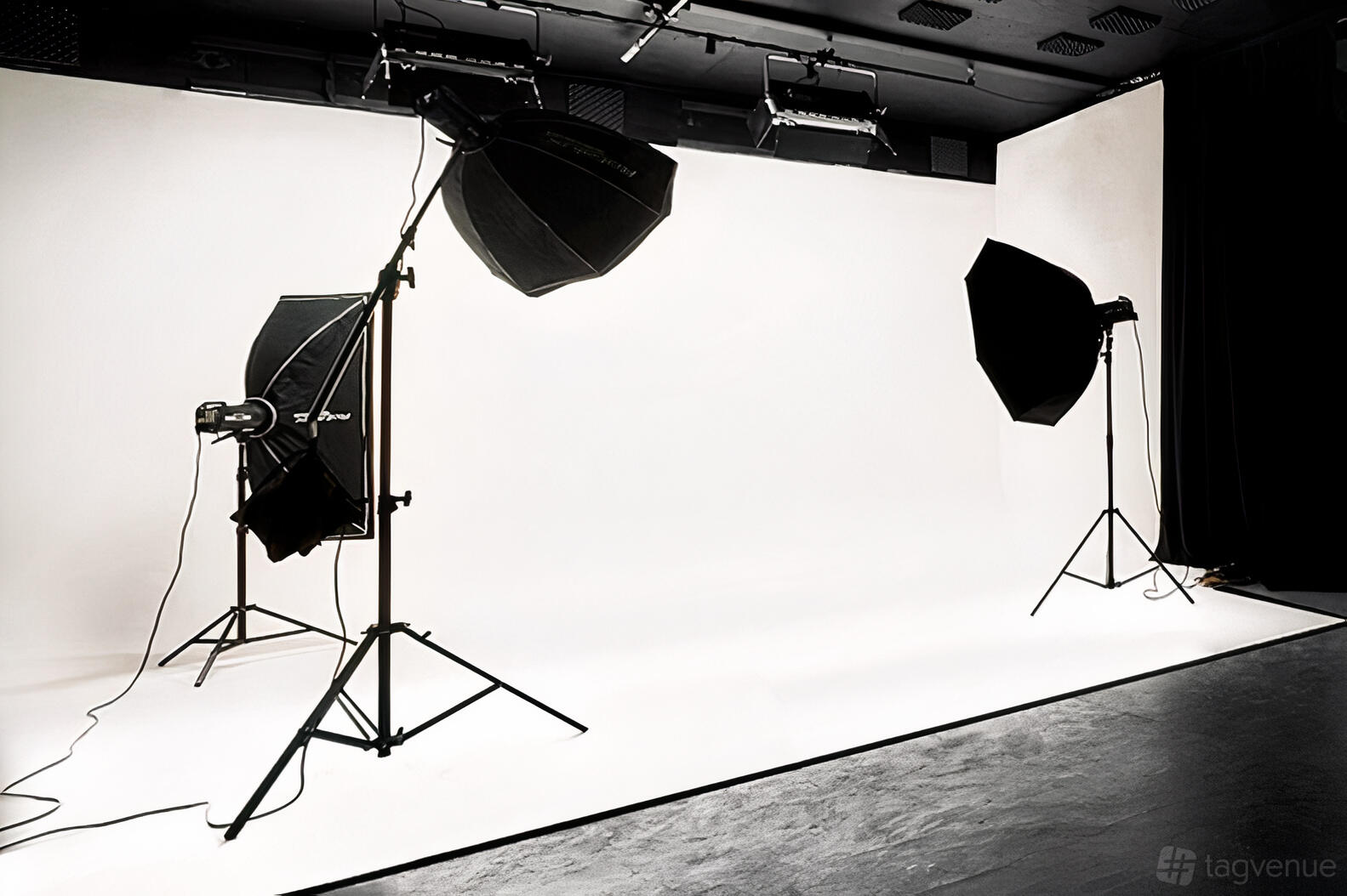 A photo studio with a seamless white cyclorama backdrop and mounted softbox lighting at One Zero One The Studio.