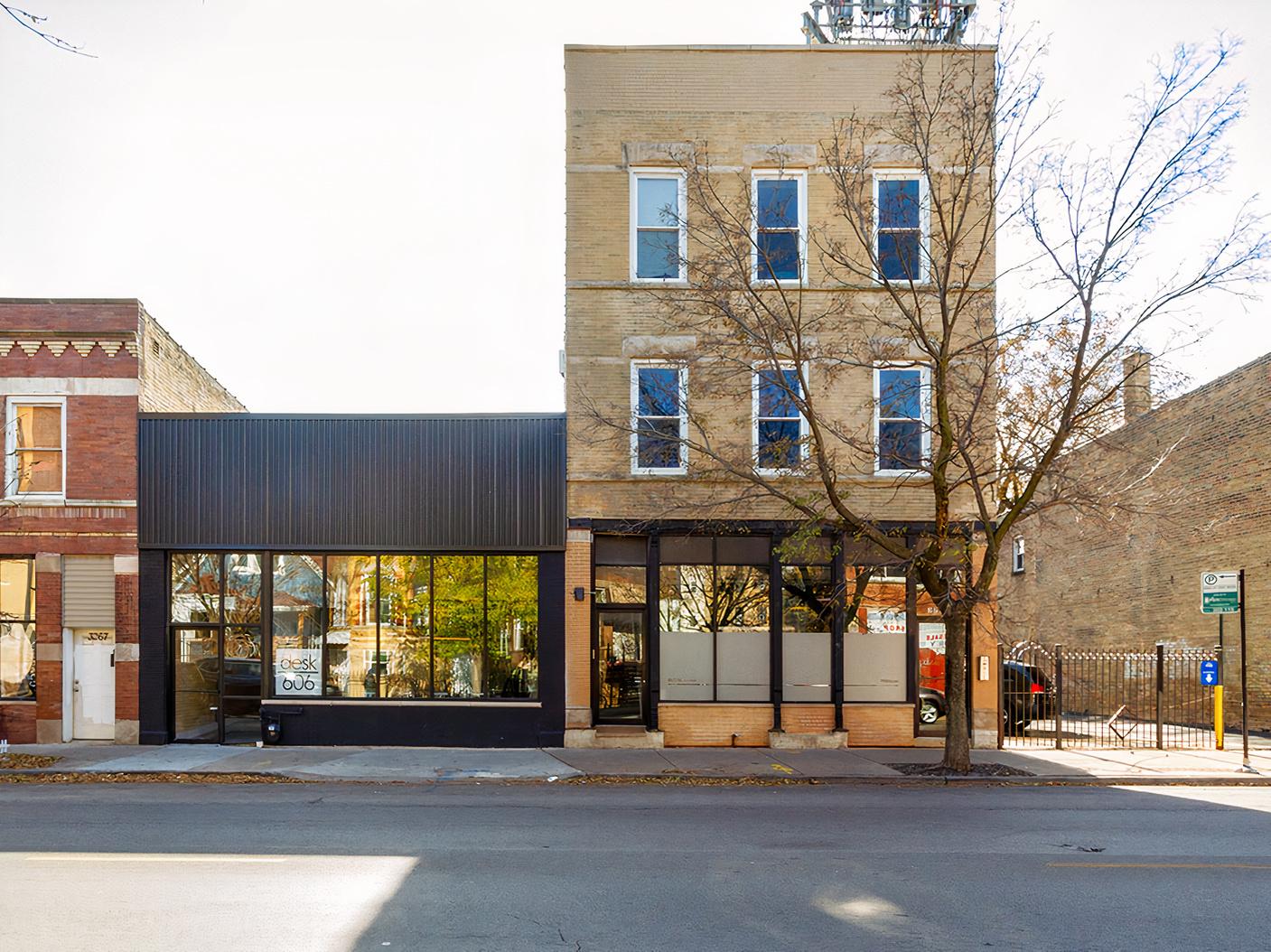 A coworking space with large front windows and a modern black facade at Desk 606.