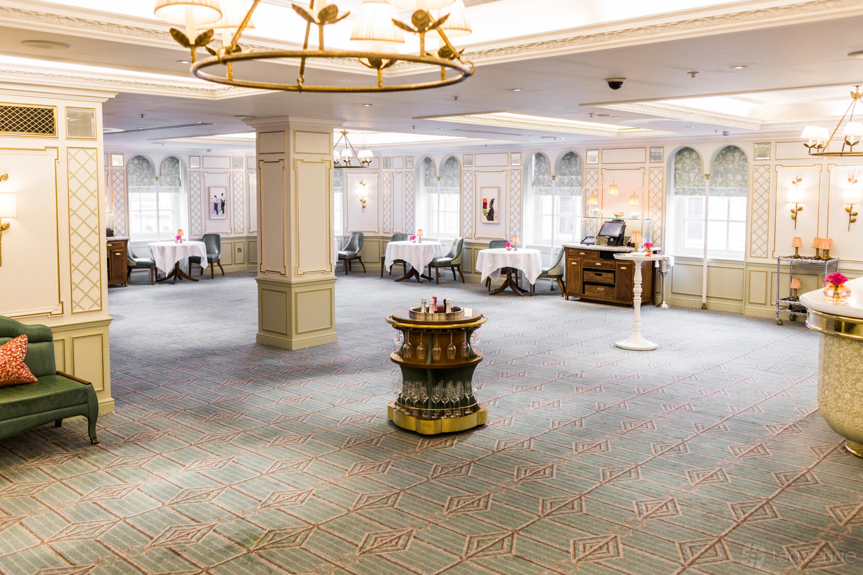 An event venue with elegant chandeliers, patterned carpet, and arched windows at Fortnum & Mason.