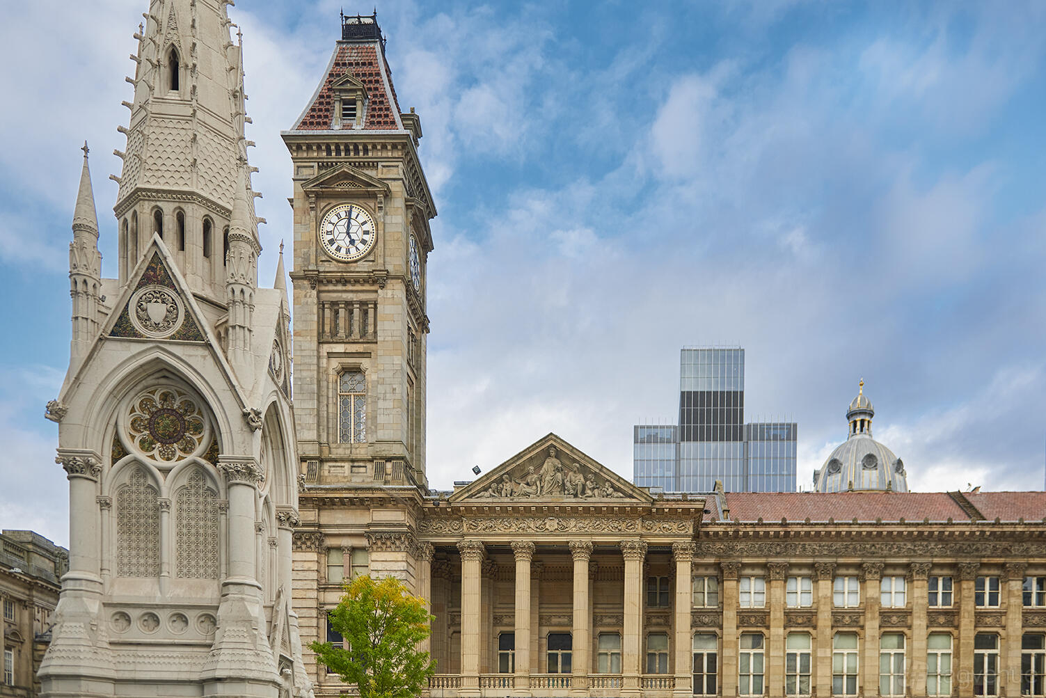 An exterior view of historic buildings with ornate stonework and clock tower near Orelle restaurant.