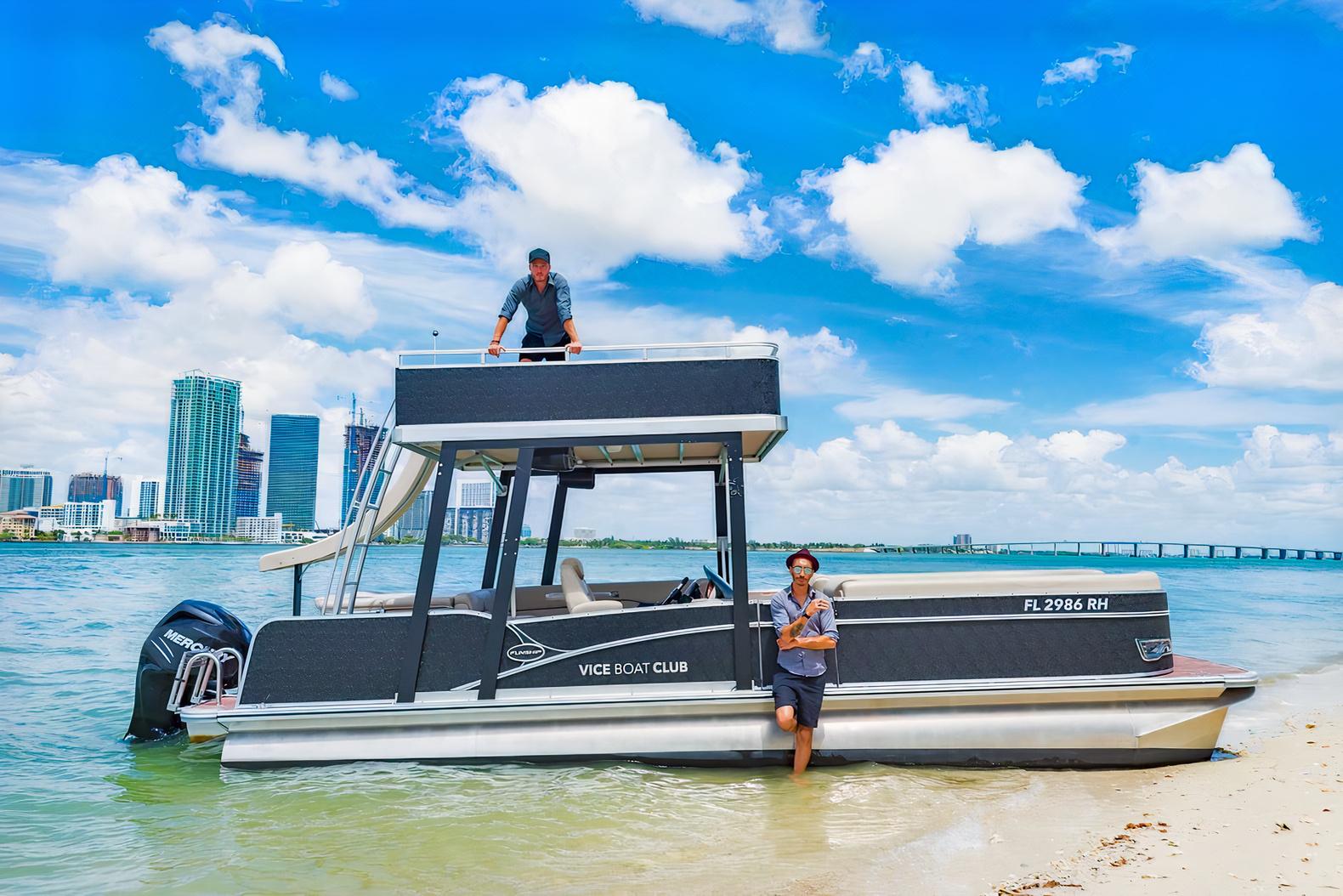 A docked pontoon boat with an upper deck and city skyline views at Vice Boat Club.