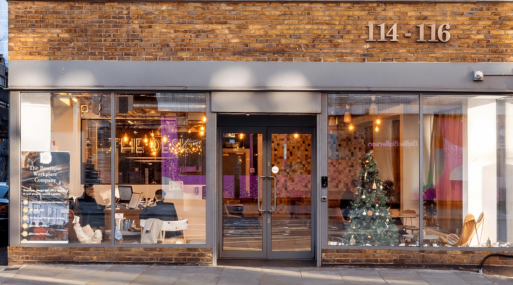 A meeting centre with a glass entrance, exposed brick facade, and decorated Christmas tree at Curtain Road.