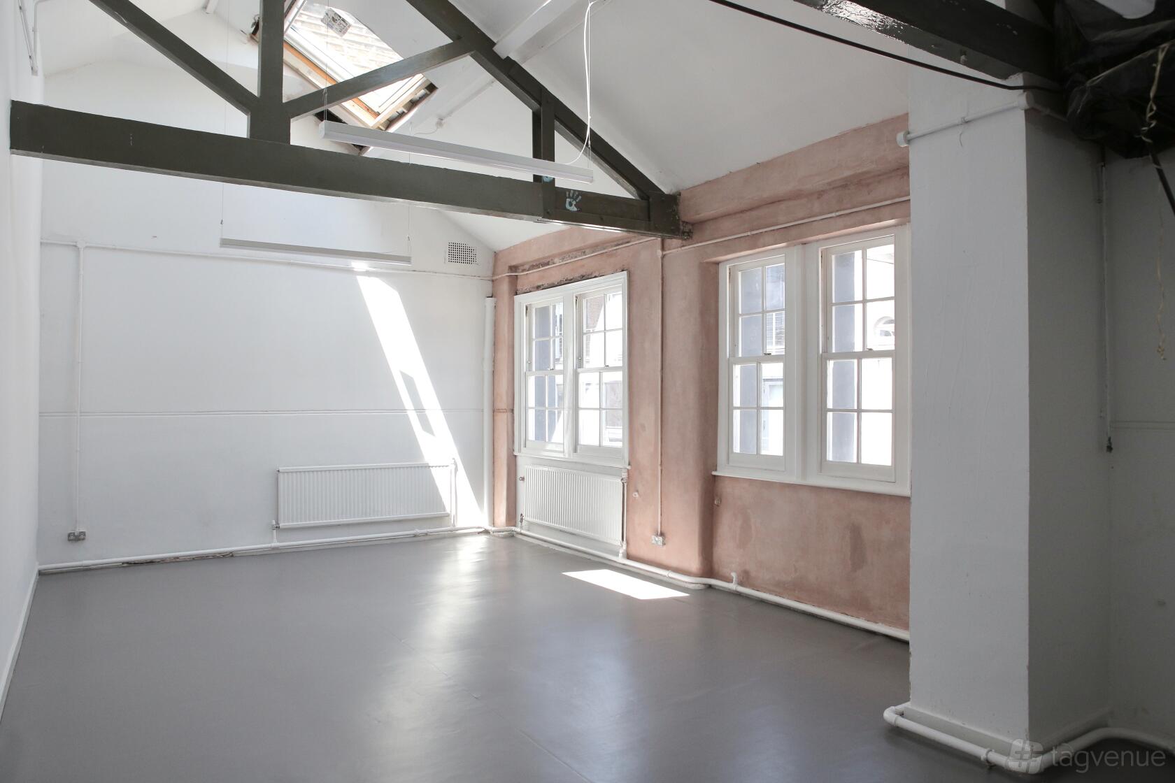 A drama studio with high ceilings, skylight, and large windows at City Academy at 10 Herbal Hill.