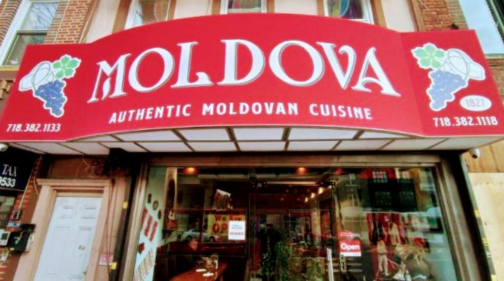 A restaurant exterior with a red awning displaying 'Moldova Authentic Moldovan Cuisine' at Moldova Restaurant.
