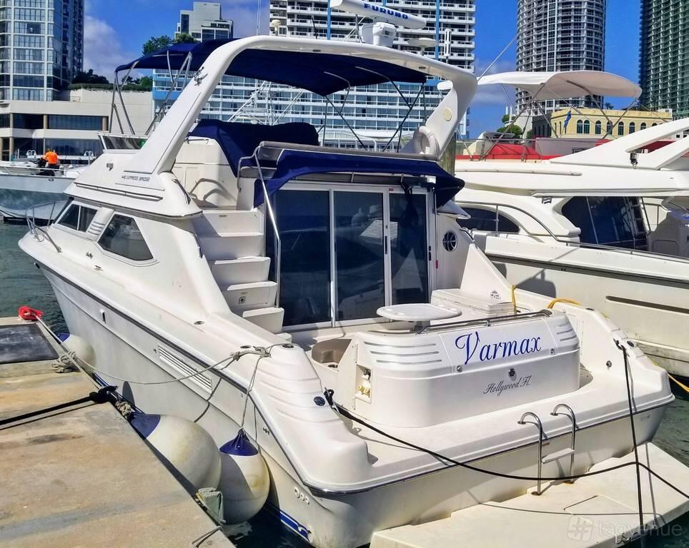 A docked yacht with a covered upper deck, glass sliding doors, and waterfront view at Boat Charters.