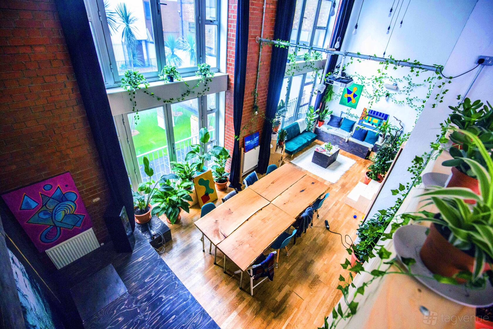 A film studio with high ceilings, exposed brick walls, large windows, and eclectic furnishings at House of Transformation - Film Studio.