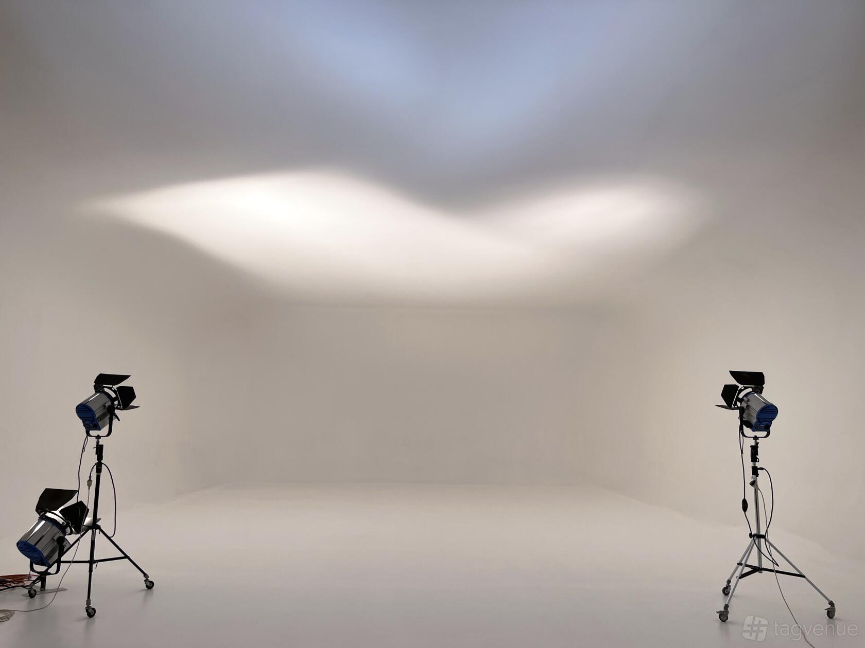 A photo studio with a seamless white cyclorama wall and three studio lights at The Good Egg Studio.