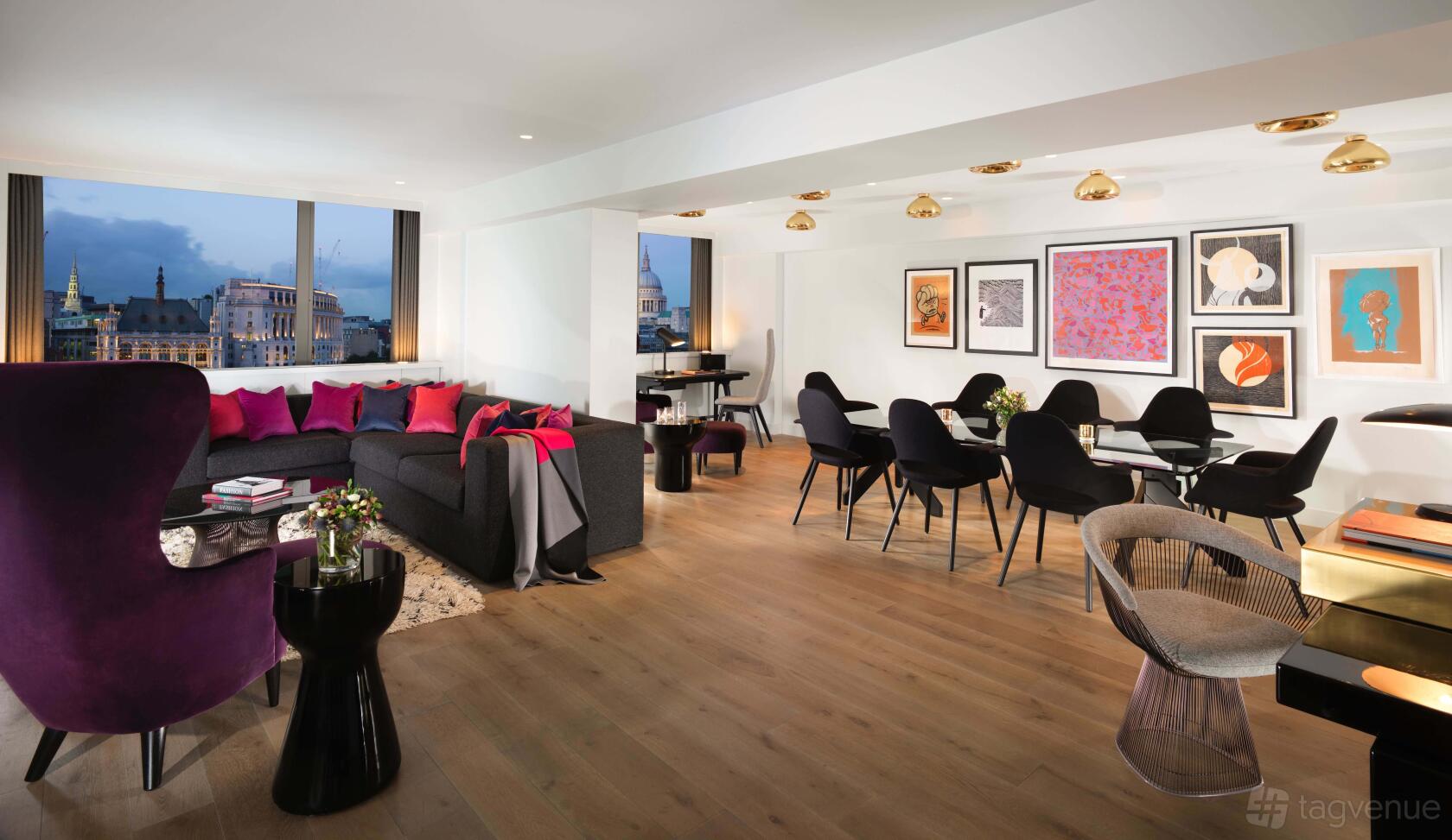 A hotel suite with large windows, wooden floors, a grand piano, and contemporary art at Sea Containers Hotel.