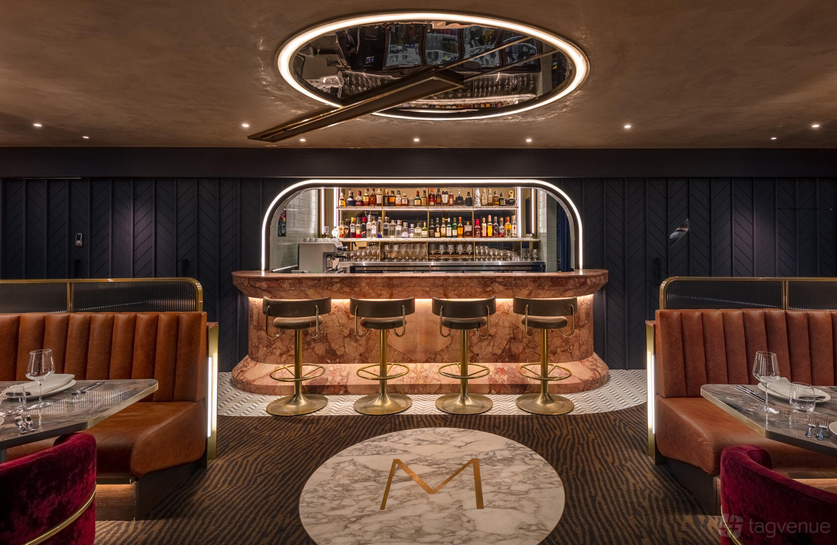 A cafe with a marble bar, gold-trimmed barstools, and velvet booths at The aVenue.