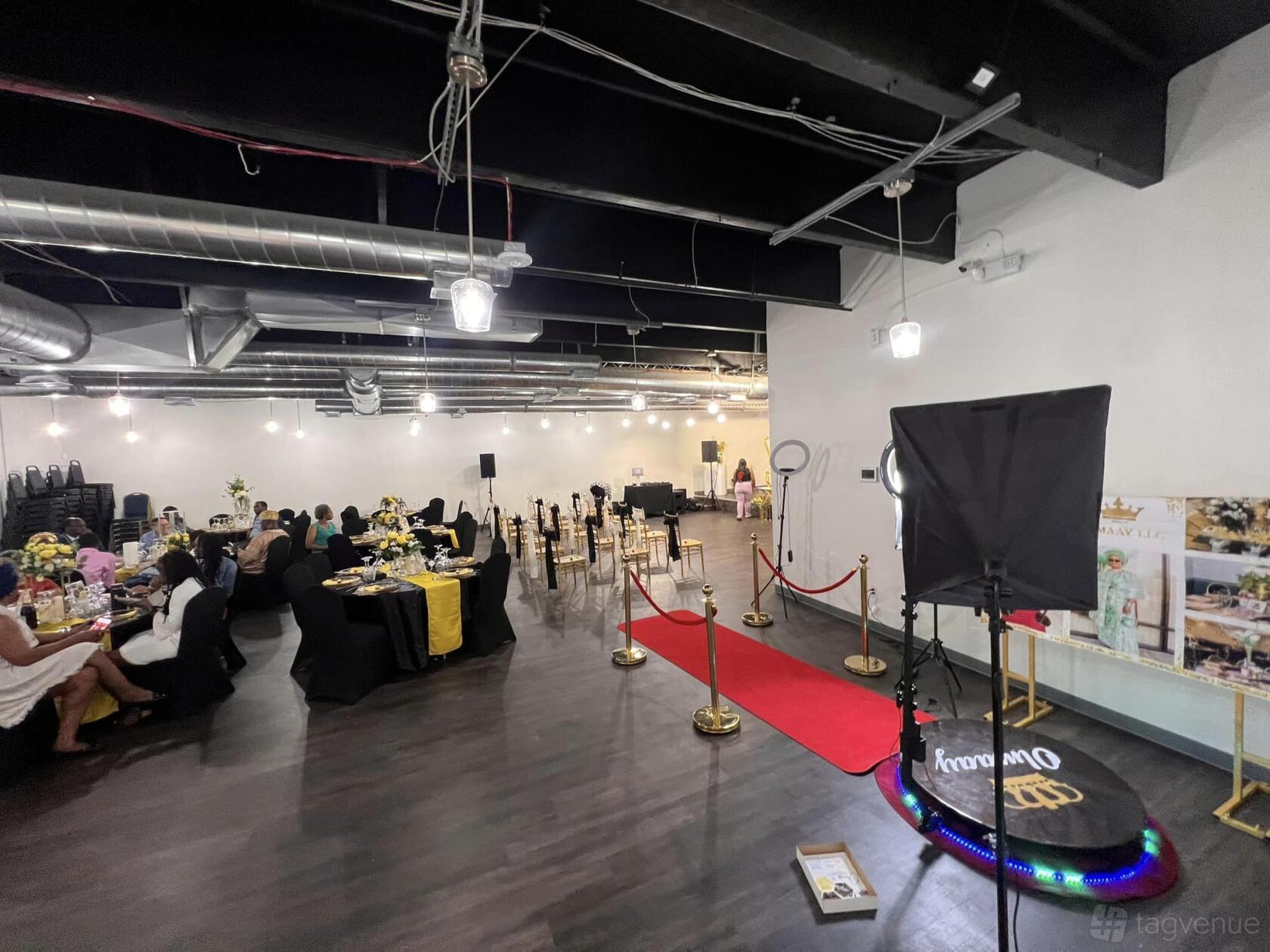 An event venue with banquet tables, a red carpet, and exposed ductwork at Celebrity Confetti Events Place.