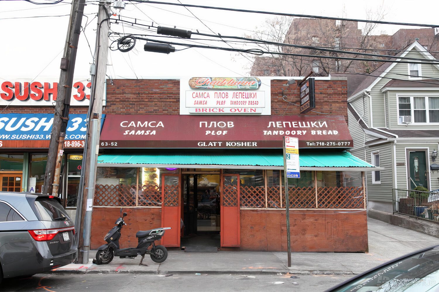 A brick restaurant facade with awning, signage in Cyrillic and English, and an open entrance at Chaikhana Sem Sorok.