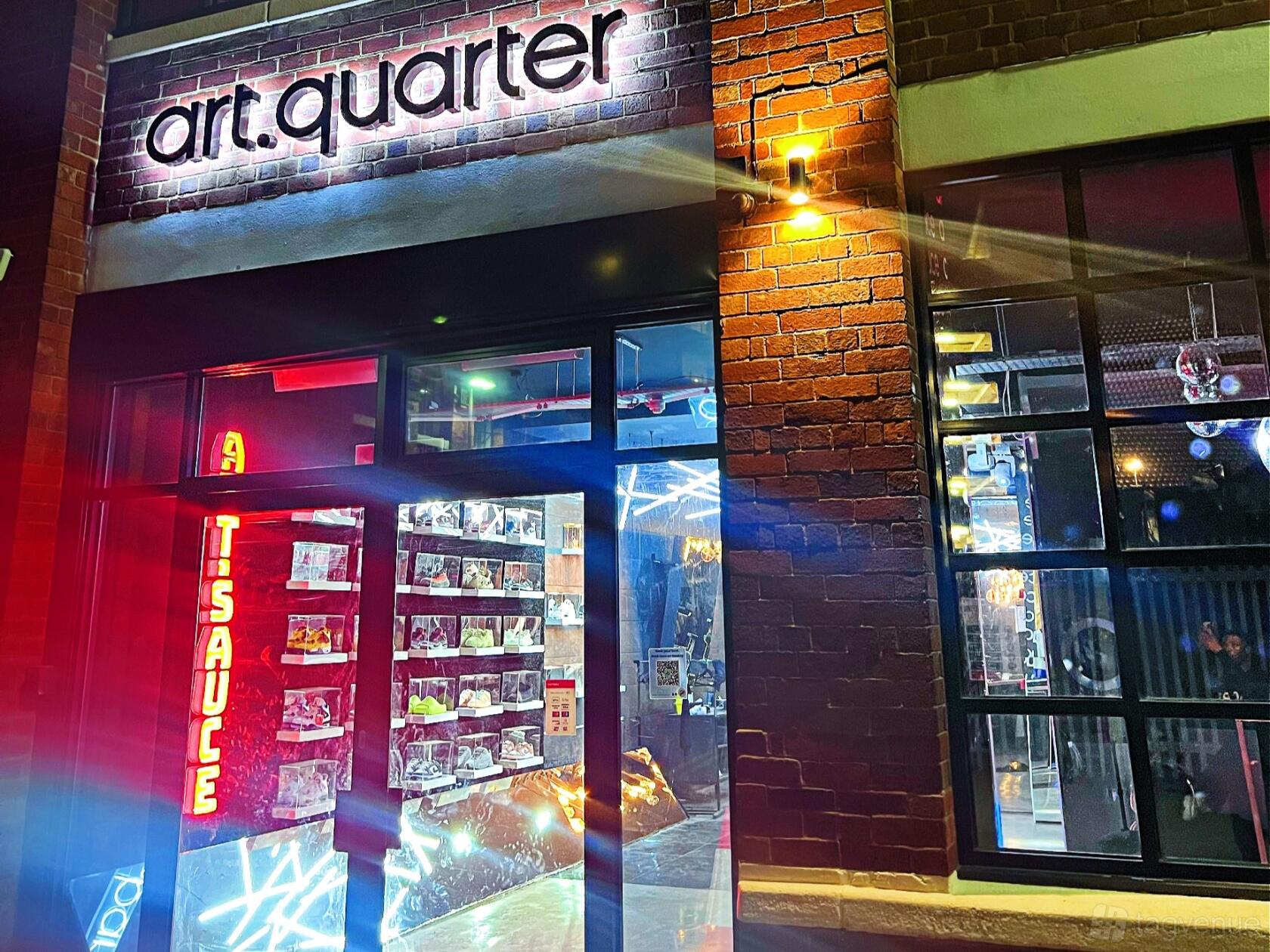 A versatile event space with floor-to-ceiling windows, exposed brick walls, and neon signage at ARTBOX.