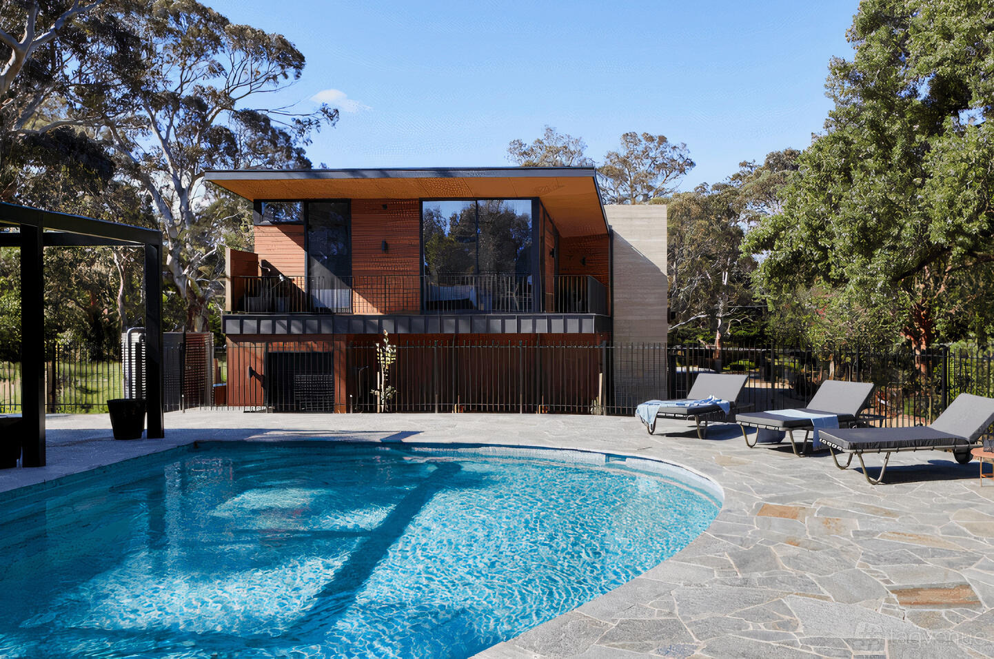 A country house with an outdoor swimming pool, stone patio, and lounge chairs at Atlas Retreat.