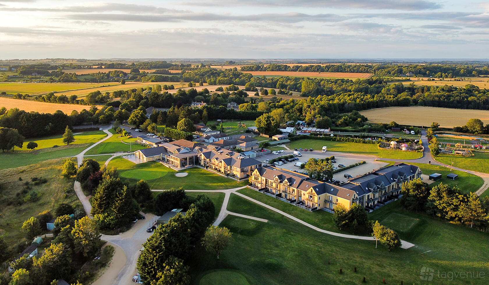 A hotel with stone buildings, spacious grounds, and surrounding countryside views at Cotswolds Hotel & Spa.