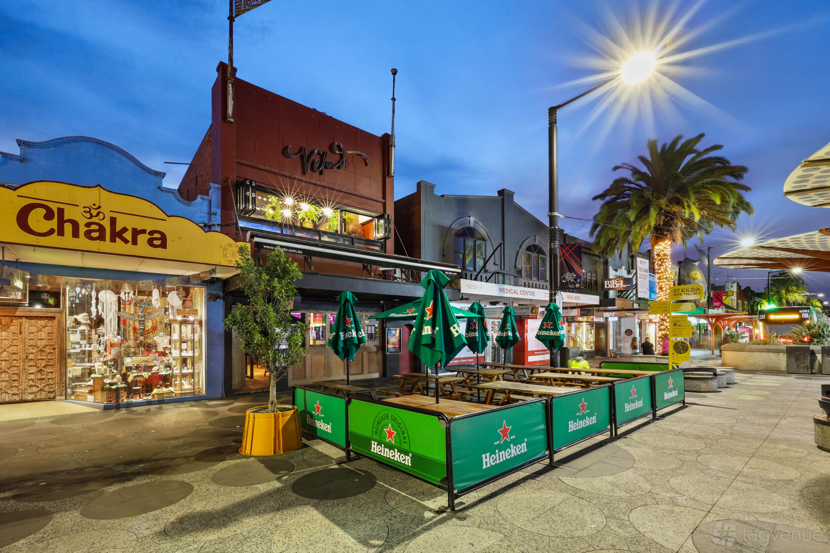 A pub with a sidewalk patio, green umbrellas, and branded barriers at Jekyll & Hyde.